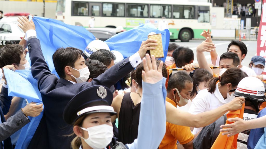 People react after gunshots in Nara, western Japan Friday, July 8, 2022. Japan’s former Prime Minister Shinzo Abe was in heart failure after apparently being shot during a campaign speech Friday in western Japan, NHK public television said Friday.(Kyodo News via AP) TKMY805
