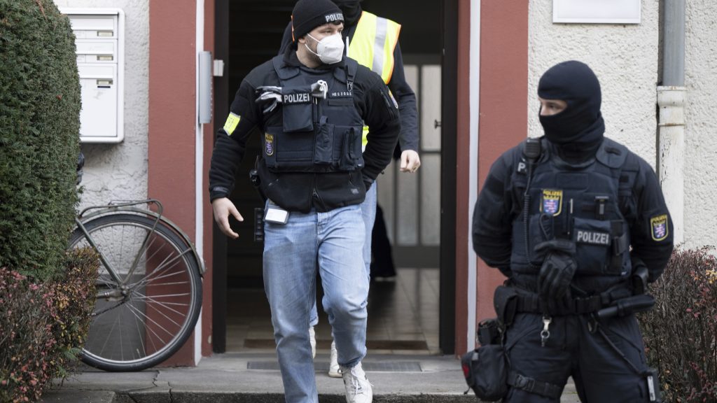 Police officers walk in front of a searched property in Frankfurt during a raid against so-called 'Reich citizens' in Frankfurt, Germany, Wednesday, Dec. 7, 2022. Thousands of police carried out a series of raids across much of Germany on Wednesday against suspected far-right extremists who allegedly sought to overthrow the state by force. Federal prosecutors said some 3,000 officers conducted searches at 130 sites in 11 of Germany's 16 states against adherents of the so-called Reich Citizens movement. Some members of the grouping reject Germany's postwar constitution and have called for the overthrow of the government. (Boris Roessler/dpa via AP) DSOB105