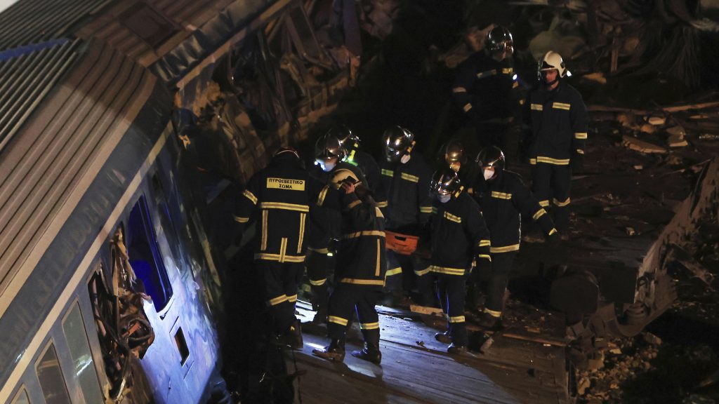 Firefighters operate after a collision in Tempe near Larissa city, Greece early Wednesday, March 1, 2023. A train carrying hundreds of passengers has collided with an oncoming freight train in northern Greece, killing and injuring dozens passengers. (George Kidonas/InTime News via AP) ATH802
