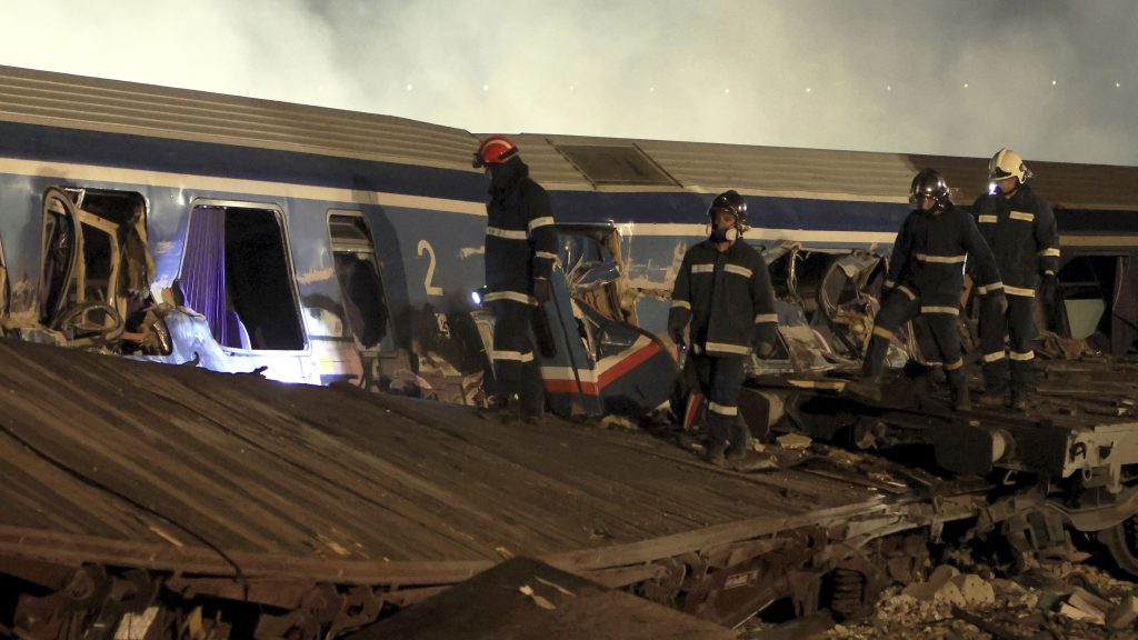 Firefighters operate after a collision in Tempe near Larissa city, Greece early Wednesday, March 1, 2023. A train carrying hundreds of passengers has collided with an oncoming freight train in northern Greece, killing and injuring dozens passengers. (George Kidonas/InTime News via AP) ATH803