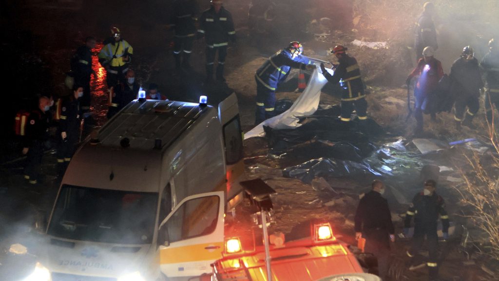 Firefighters collect bodies after a collision in Tempe near Larissa city, Greece early Wednesday, March 1, 2023. A train carrying hundreds of passengers has collided with an oncoming freight train in northern Greece, killing and injuring dozens passengers. (George Kidonas/InTime News via AP) ATH801