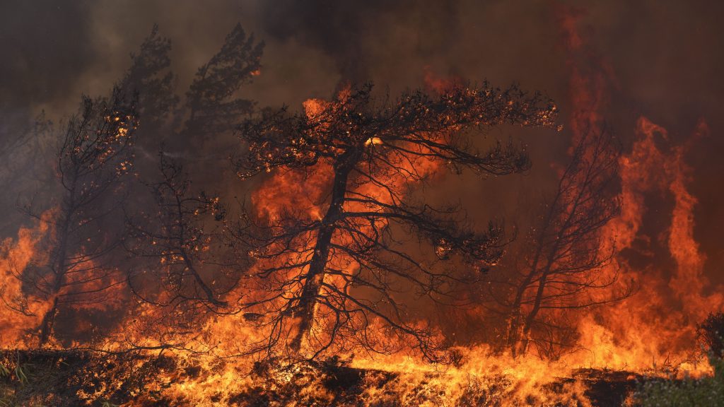 Flames burn a forest in Vati village, on the Aegean Sea island of Rhodes, southeastern Greece, on Tuesday, July 25, 2023. A third successive heat wave in Greece pushed temperatures back above 40 degrees Celsius (104 degrees Fahrenheit) across parts of the country Tuesday following more nighttime evacuations from fires that have raged out of control for days. (AP Photo/Petros Giannakouris) XTS118