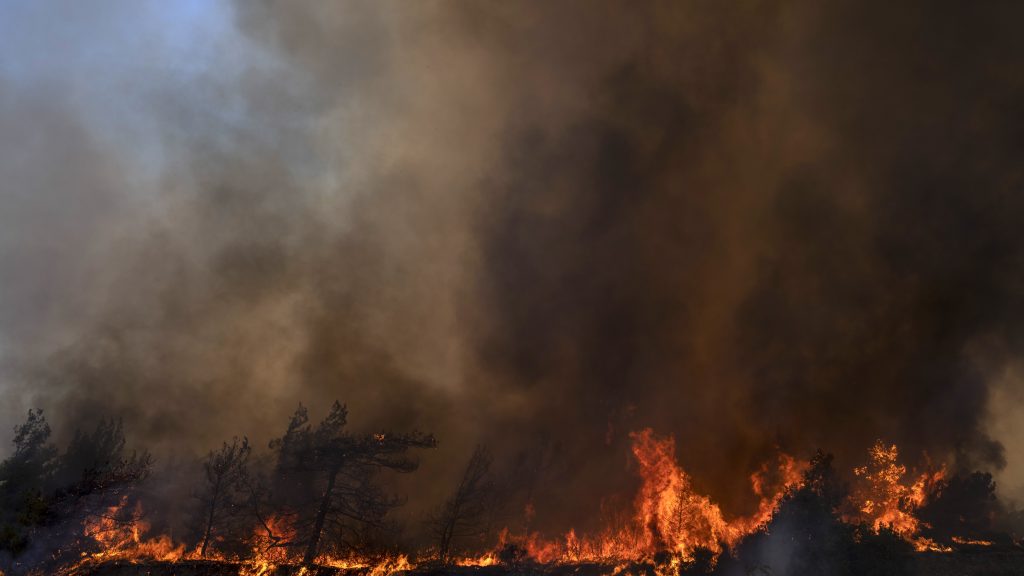 Flames burn a forest during a wildfire in Vati village, on the Aegean Sea island of Rhodes, southeastern Greece, on Tuesday, July 25, 2023. A third successive heat wave in Greece pushed temperatures back above 40 degrees Celsius (104 degrees Fahrenheit) across parts of the country Tuesday following more nighttime evacuations from fires that have raged out of control for days. (AP Photo/Petros Giannakouris) XTS124