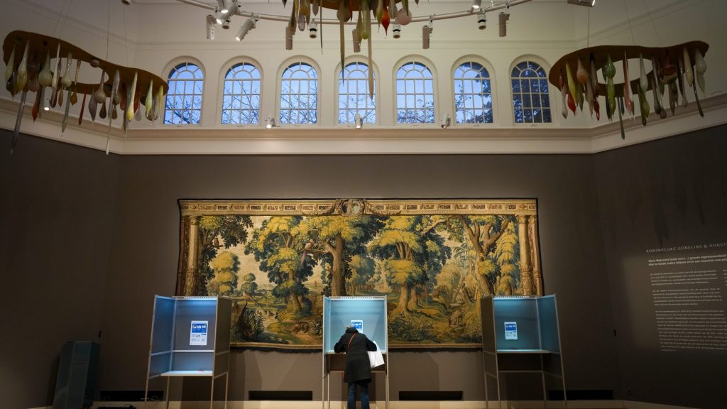 A woman prepares to cast her ballot at the Rijksmuseum Twenthe museum, which offers a free entrance to those who want to vote in Enschede, Netherlands, Wednesday, Nov. 22, 2023. (AP Photo/Peter Dejong) XVG145