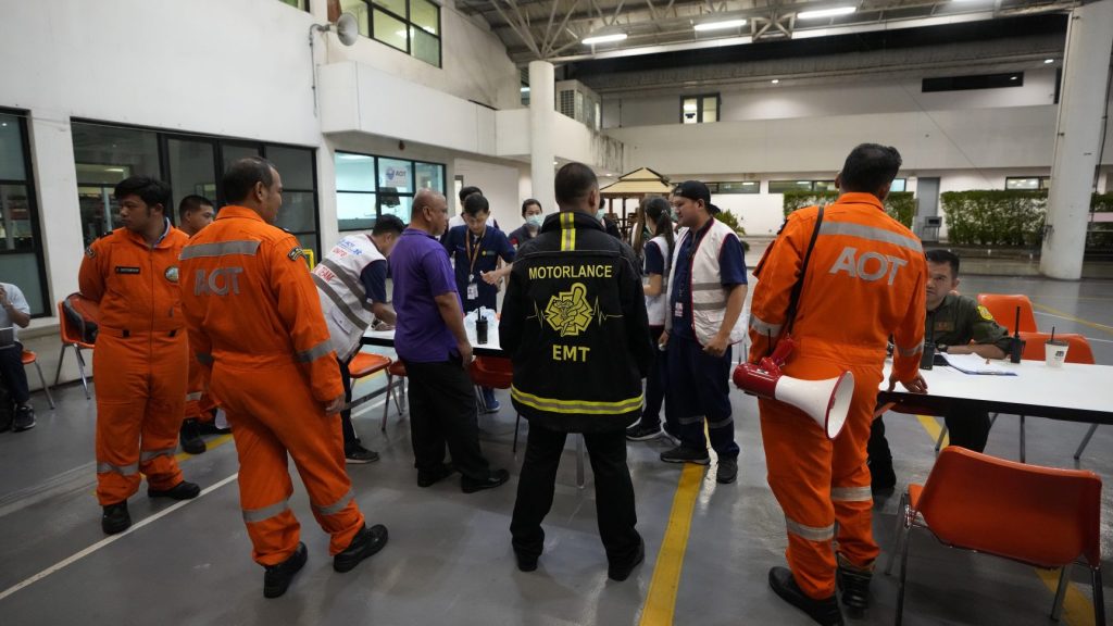 Members of a rescue team discuss after a London-Singapore flight was diverted to Bangkok due to severe turbulence, in Bangkok, Thailand, Tuesday, May 21, 2024. The plane apparently plummeted for a number of minutes before it was diverted to Bangkok, where emergency crews rushed to help injured passengers amid stormy weather, Singapore Airlines said Tuesday. (AP Photo/Sakchai Lalit) SLX106