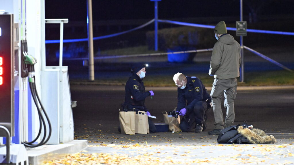 OSBY, SVERIGE 20241017
Polis och kriminaltekniker på plats vid en bensinmack på Såggatan i Osby på onsdagskvällen efter larm om en skottlossning. Enligt polisen haren person påträffats med skottskador.
Foto: Johan Nilsson / TT / Kod 50090