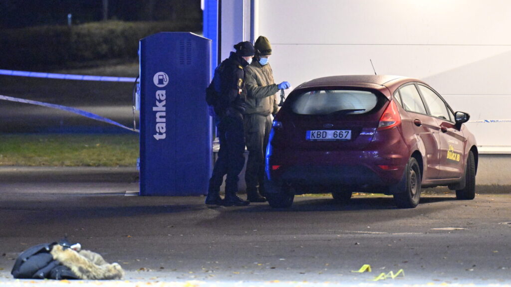 OSBY, SVERIGE 20241017
Polis och kriminaltekniker på plats vid en bensinmack på Såggatan i Osby på onsdagskvällen efter larm om en skottlossning. Enligt polisen haren person påträffats med skottskador.
Foto: Johan Nilsson / TT / Kod 50090