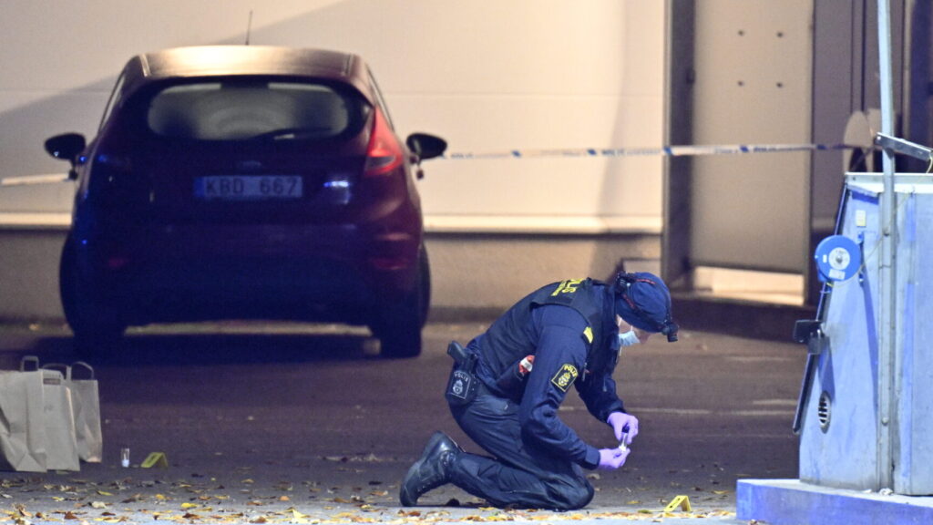 OSBY, SVERIGE 20241017
Polis och kriminaltekniker på plats vid en bensinmack på Såggatan i Osby på onsdagskvällen efter larm om en skottlossning. Enligt polisen haren person påträffats med skottskador.
Foto: Johan Nilsson / TT / Kod 50090