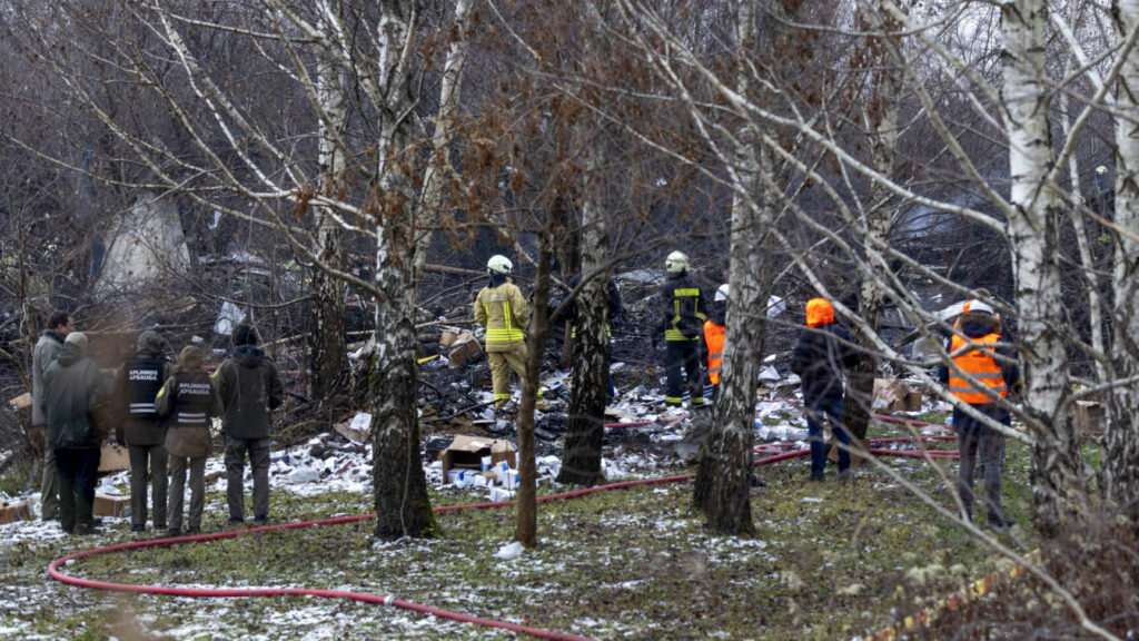 Lithuanian Emergency Ministry employees work near the place where a DHL cargo plane crashed into a house near the Lithuanian capital Vilnius, Lithuania, Lithuania, Monday, Nov. 25, 2024. (AP Photo/Mindaugas Kulbis) XAZ109