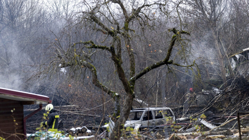 Lithuanian Emergency Ministry employees work near the place where a DHL cargo plane crashed into a house near the Lithuanian capital Vilnius, Lithuania, Monday, Nov. 25, 2024. (AP Photo/Mindaugas Kulbis) XAZ107