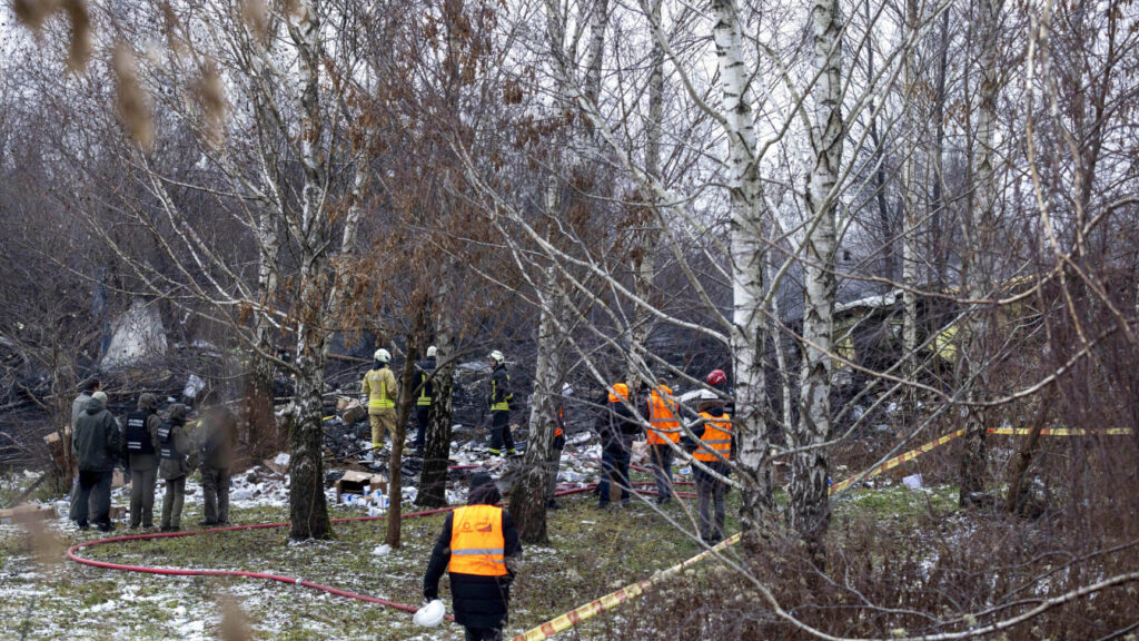 Lithuanian Emergency Ministry employees work near the place where a DHL cargo plane crashed into a house near the Lithuanian capital Vilnius, Lithuania, Monday, Nov. 25, 2024. (AP Photo/Mindaugas Kulbis) XAZ108