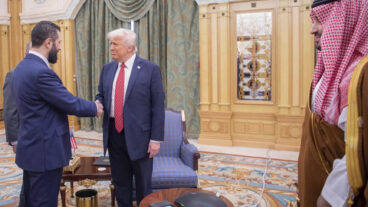 In this photo released by the Saudi Royal Palace, Syria's interim President Ahmad al-Sharaa, left, shakes hands with President Donald Trump, centre, in Riyadh, Saudi Arabia, Wednesday, May 14, 2025. At right is Saudi Crown Prince Mohammed bin Salman.(Bandar Aljaloud/Saudi Royal Palace via AP)  XHM101