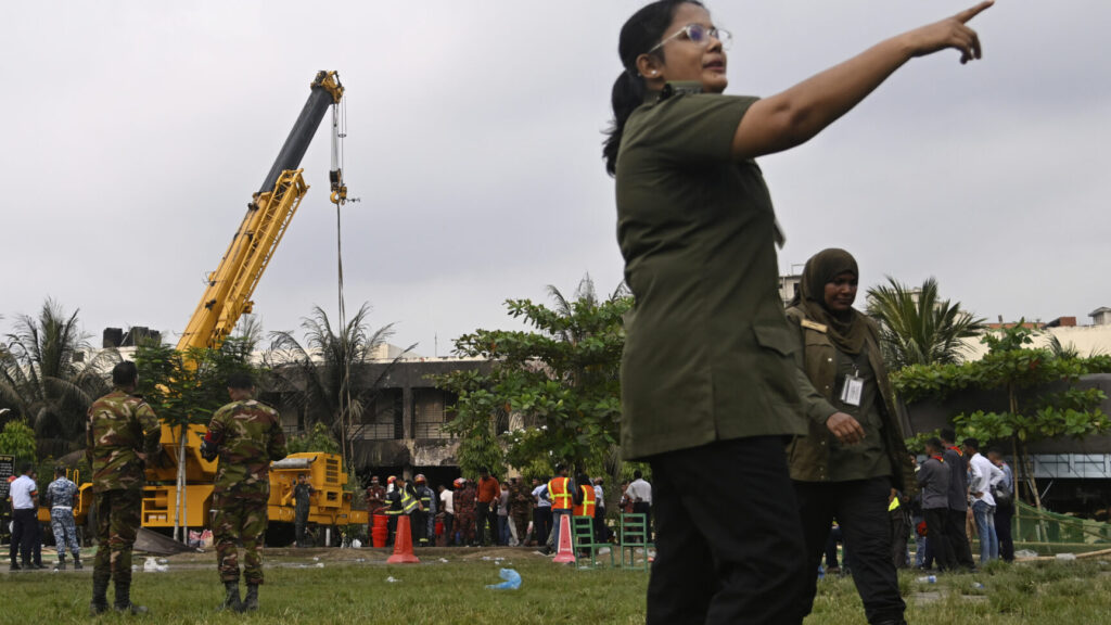 Police officials and firemen work at the site after a Bangladesh Air Force training aircraft crashed onto a school campus shortly after takeoff in Dhaka, Bangladesh, Monday, July 21, 2025. (AP Photo/Mahmud Hossain Opu) OPU106
