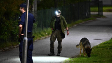 STOCKHOLM, SVERIGE 20250711
Polis på plats med hundförare i Vårby i Huddinge söder om Stockholm efter att en man skjutits på fredagskvällen.  Mannen är förd till sjukhus, skadeläget är oklart. Jakt på gärninspersonerna pågår i flera kommuner i södra Stockholm uppger polisen. 
Foto: Anders Wiklund / TT / Kod 10040