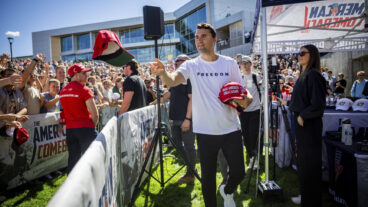 Charlie Kirk hands out hats before speaking at Utah Valley University in Orem, Utah, Wednesday, Sept. 10, 2025. (Tess Crowley/The Deseret News via AP) UTSAL201