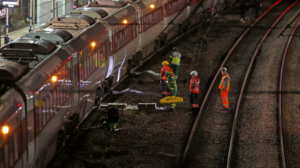 Emergency personnel inspect a train at the Huntingdon, England, train station in Cambridgeshire after people were stabbed Saturday, Nov. 1, 2025. (Chris Radburn/PA via AP) uklpa608