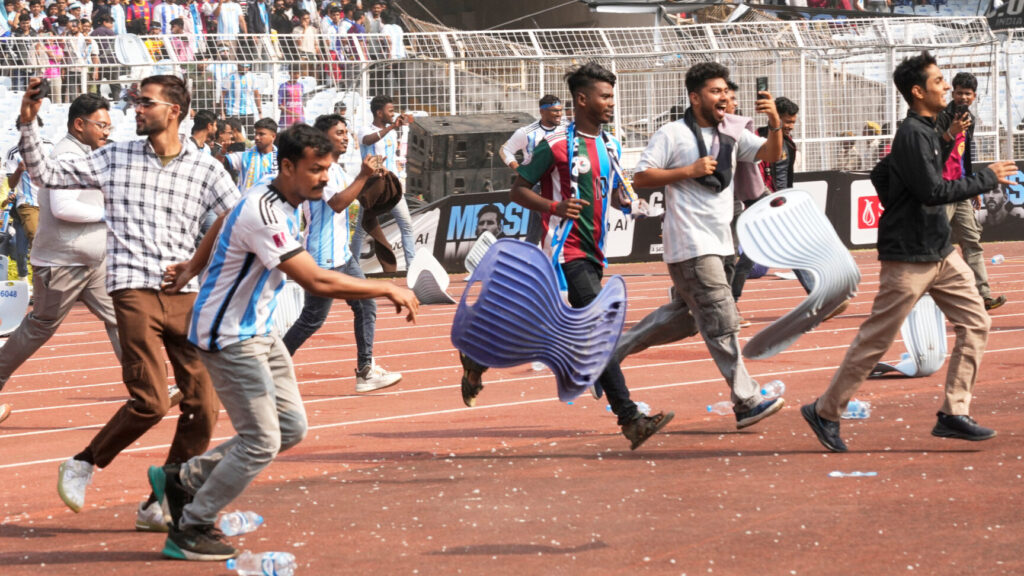 Indian fans vandalize stadium chairs as they run on to the field after failing to get a glimpse of Argentine soccer star Lionel Messi at the Salt Lake Stadium, in Kolkata, India, Saturday, Dec. 13, 2025. (AP Photo/Bikas Das) XBD103