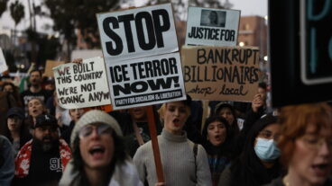 Demonstrators hold signs during a protest in response to the fatal shooting of 37-year-old Alex Pretti in Minneapolis earlier in the day Saturday, Jan. 24, 2026, in Los Angeles. (AP Photo/Caroline Brehman)  CACB609
