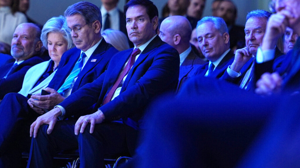 United States Secretary of State Marco Rubio, center, sits with U.S. Treasury Secretary Scott Bessent, third left, and White House chief of staff Susie Wiles, second left, as they listen to the address of President Donald Trump during the Annual Meeting of the World Economic Forum in Davos, Switzerland, Wednesday, Jan. 21, 2026. (AP Photo/Evan Vucci) XVM147