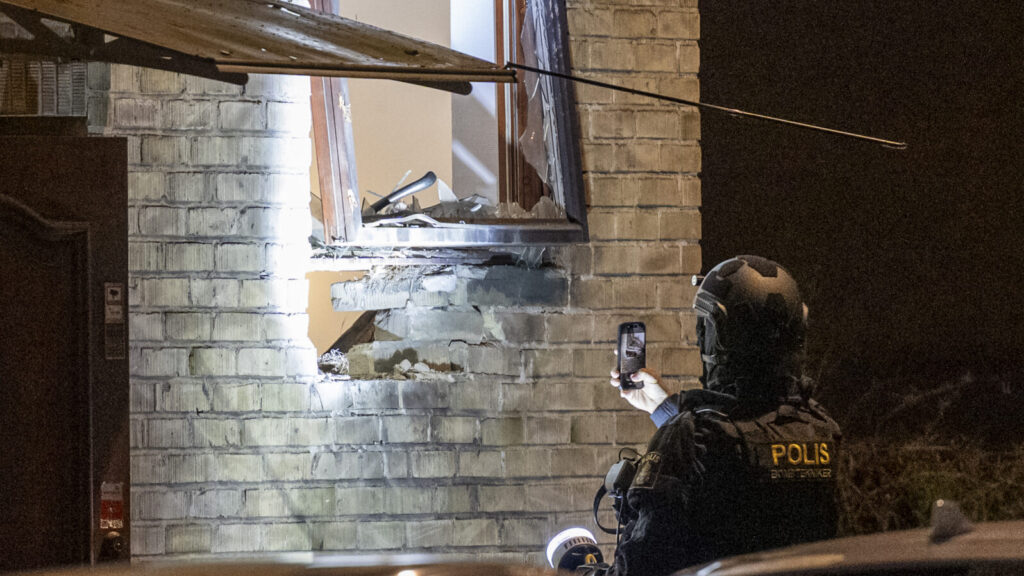 MALMÖ 2026-04-19
Polis och bombtekniker undersöker skadorna på fasaden och parkerade fordon efter en explosion vid en fastighet på Hindby i Malmö tidigt på söndagsmorgonen.
Foto: Johan Nilsson / TT / Kod 50090