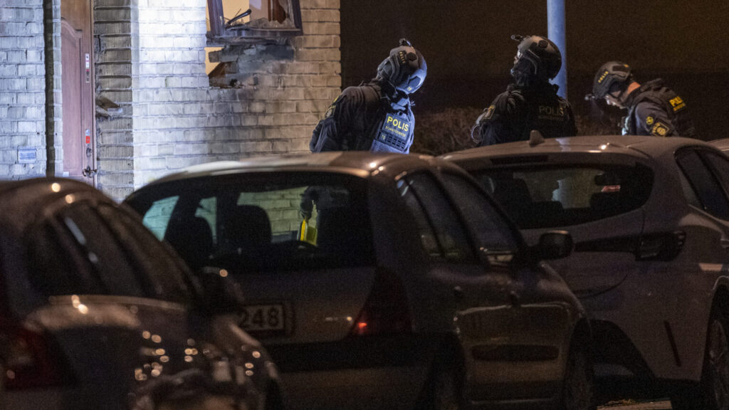 MALMÖ 2026-04-19
Polis och bombtekniker undersöker skadorna på fasaden och parkerade fordon efter en explosion vid en fastighet på Hindby i Malmö tidigt på söndagsmorgonen.
Foto: Johan Nilsson / TT / Kod 50090