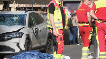 Rescue workers stand next to a damaged car that has crashed into several people in Leipzig, Germany, Monday, May 4, 2026. (Sebastian Willnow/dpa via AP)  DSOB106