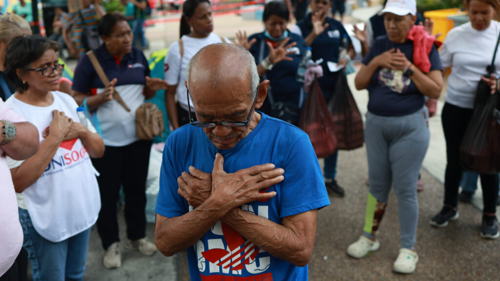 People pray for the victims at an aid collection center for people affected by the twin earthquakes in Caracas, Venezuela, Saturday, June 27, 2026. (AP Photo/Javier Campos) XRM740
