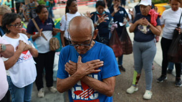 People pray for the victims at an aid collection center for people affected by the twin earthquakes in Caracas, Venezuela, Saturday, June 27, 2026. (AP Photo/Javier Campos)  XRM740