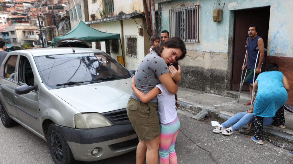 A woman embraces a child after an earthquake in Caracas, Venezuela, Wednesday, June 24, 2026. (AP Photo/Pedro Mattey) XRM464