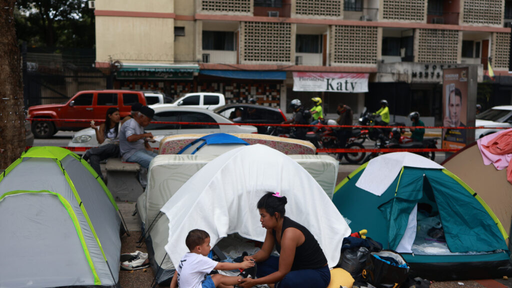 People camp on a street three days after twin earthquakes struck Caracas, Venezuela, Saturday, June 27, 2026. (AP Photo/Javier Campos) XRM739