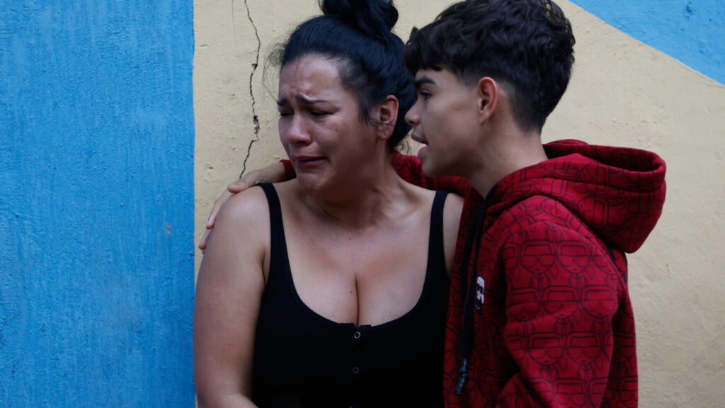 A boy conforts her mother after an earthquake in Caracas, Venezuela, Wednesday, June 24, 2026. (AP Photo/Pedro Mattey) XRM458