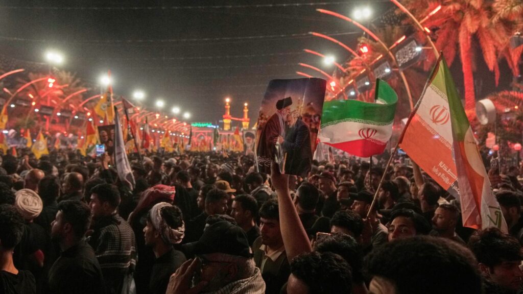 Mourners wait for the arrival of the funeral procession of the late Iranian Supreme Leader Ayatollah Ali Khamenei outside the Imam Hussein Shrine in Karbala, Iraq, Wednesday, July 8, 2026. (AP Photo/Khalil Hamra) XEM112
