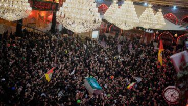 The coffin of the late Iranian Supreme Leader Ayatollah Ali Khamenei is carried through a crowd of mourners at the Imam Hussein Shrine in Karbala, Iraq, early Thursday, July 9, 2026. (AP Photo/Khalil Hamra)  XEM131