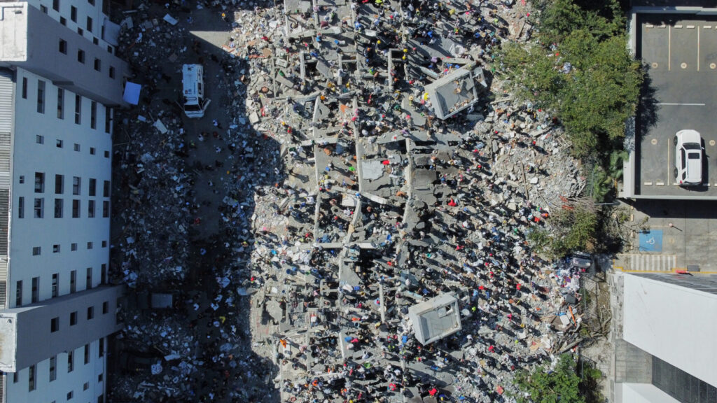 Residents and rescue workers search through the rubble after an earthquake struck Cali, Colombia, Monday, Aug. 10, 2026. (AP Photo/Santiago Saldarriaga) XRM892