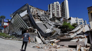 A man looks at a collapsed building after an earthquake struck Manizales, Colombia, Monday, Aug. 10, 2026. (AP Photo/Dario Cardona)  XRM896